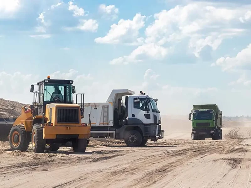 An excavator and dump trucks
